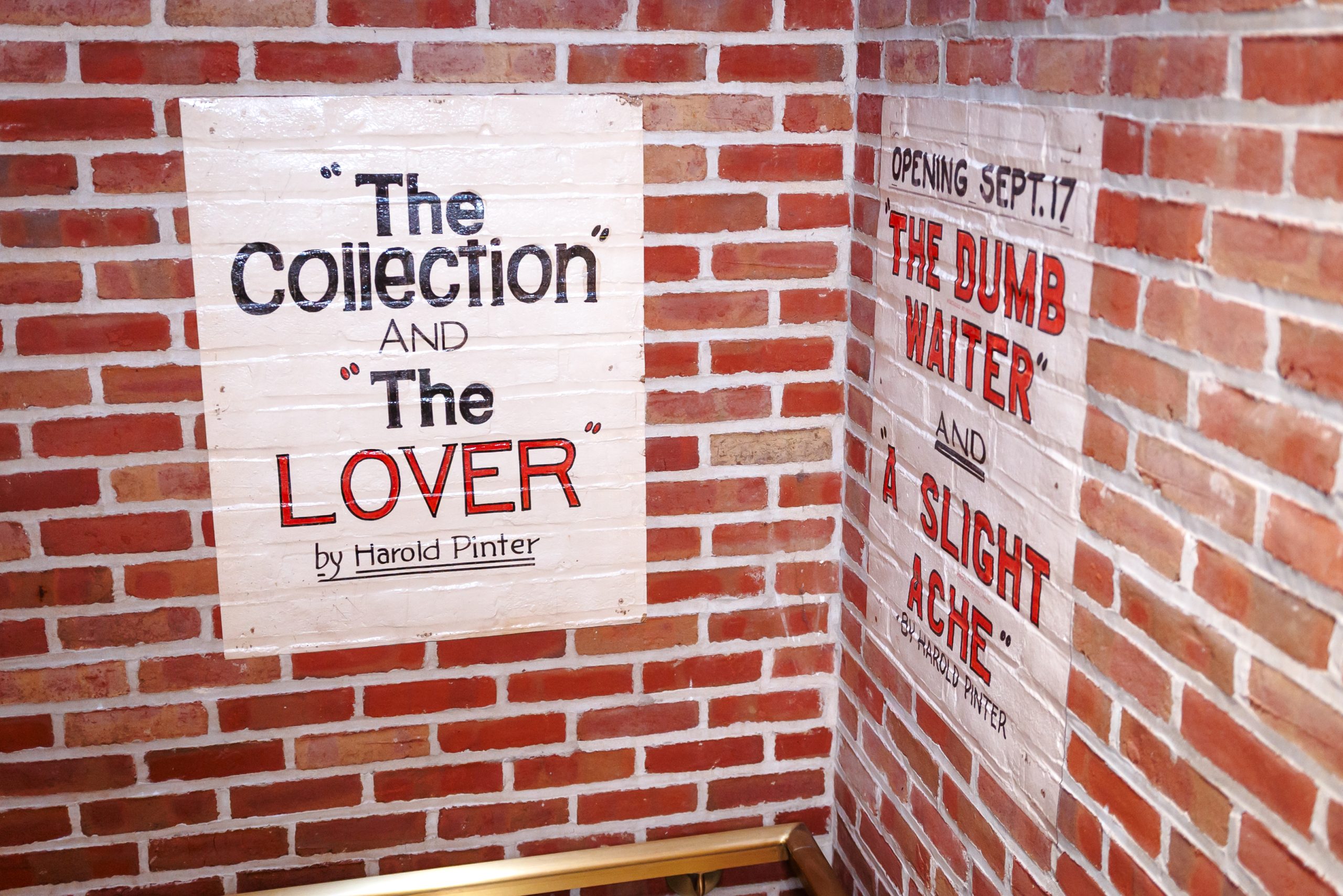 Painted signs on a brick wall advertise Harold Pinter plays: The Collection and The Lover on one wall, and The Dumb Waiter and A Slight Ache, opening Sept. 17, on the adjacent wall.