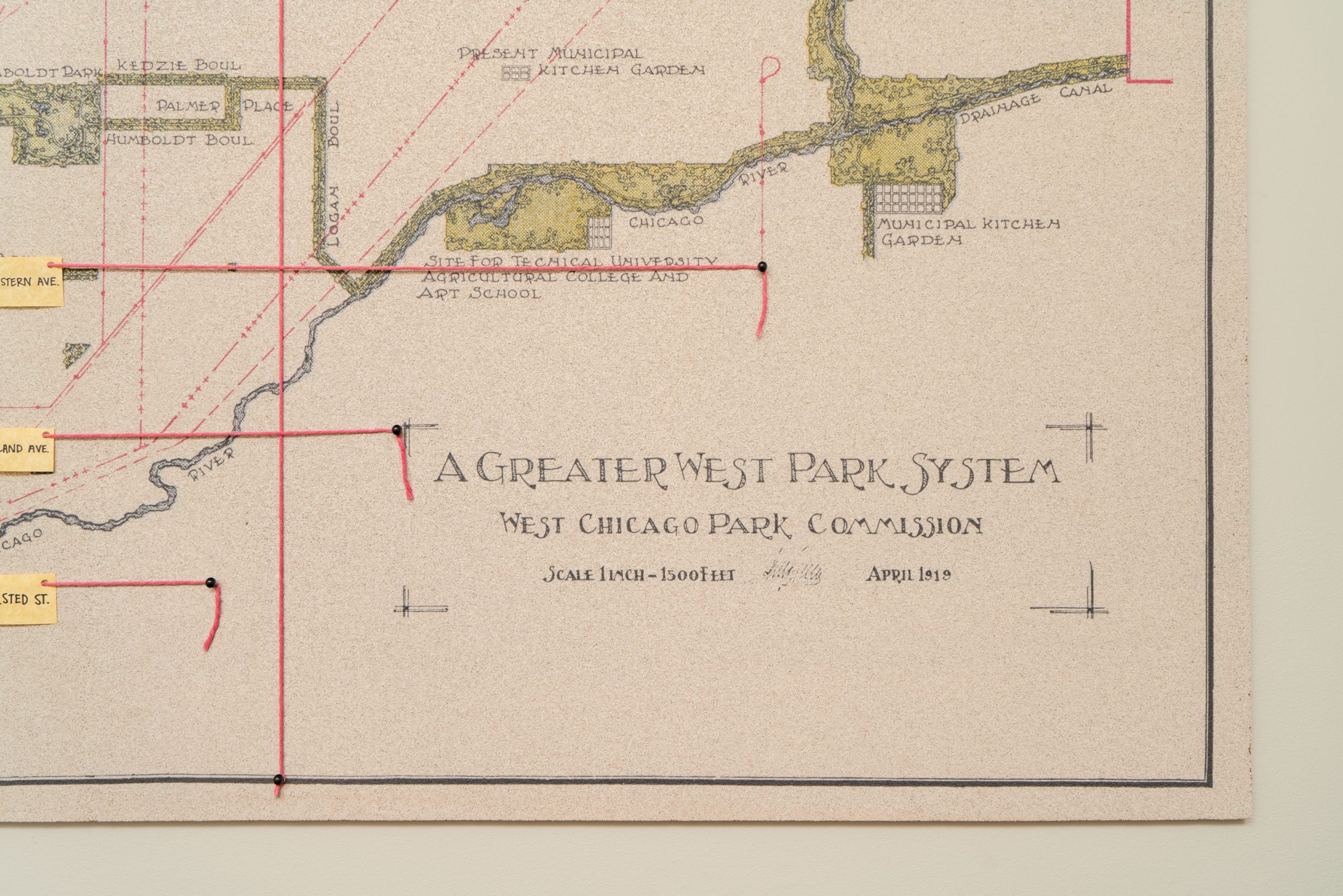 A close-up of a vintage map titled A Greater West Park System by the West Chicago Park Commission, dated April 1919, showing part of Chicago and its park areas with handwritten notes and red grid lines.
