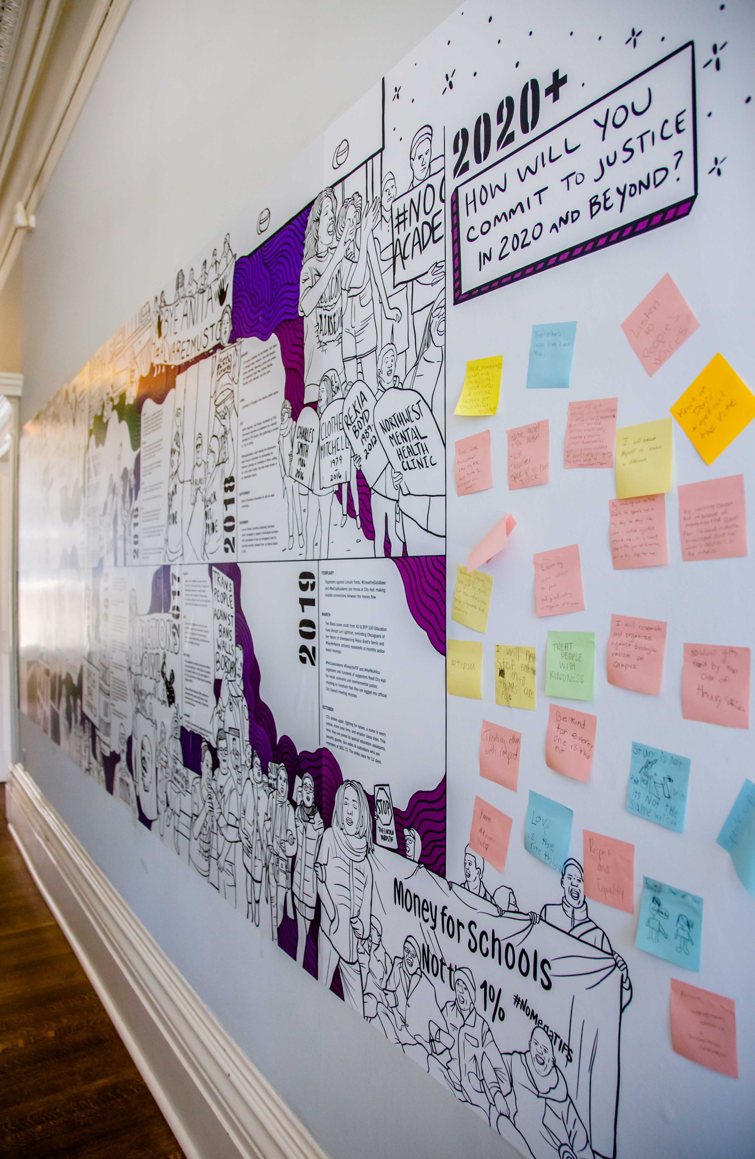 A large illustrated timeline mural on a wall features protest scenes, signs, and handwritten sticky notes. A section titled 2020+ asks, How will you commit to justice in 2020 and beyond?.