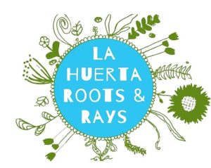 A blue circle with the white text LA HUERTA ROOTS & RAYS, surrounded by green illustrations of various plants, leaves, and roots radiating outward.